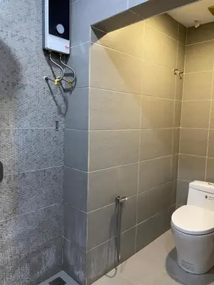 a bathroom with a toilet and a tv on the wall at Miharja Studio Private room with Auto gate Parking in Kuala Lumpur