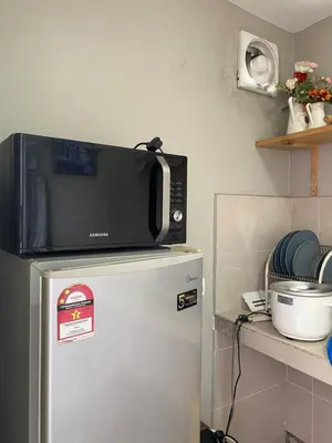 a microwave on top of a refrigerator in a kitchen at Miharja Studio Private room with Auto gate Parking in Kuala Lumpur