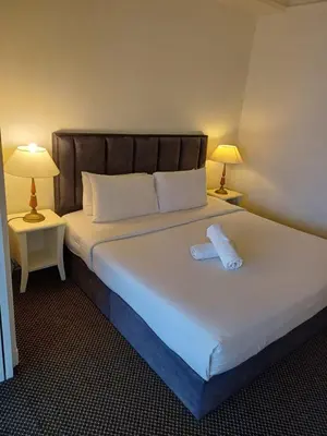 a bedroom with a large white bed with two lamps at Kuala Lumpur Grand service suite at Times Square in Kuala Lumpur