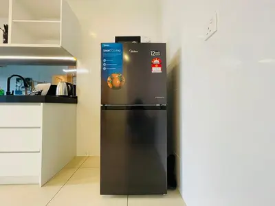a black refrigerator in a kitchen next to a wall at Reizz Residence Ampang by DeUrban in Kuala Lumpur