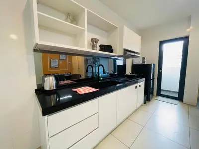 a kitchen with white cabinets and a black counter top at Reizz Residence Ampang by DeUrban in Kuala Lumpur
