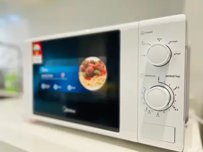 a microwave oven with a picture of a pizza at Reizz Residence Ampang by DeUrban in Kuala Lumpur