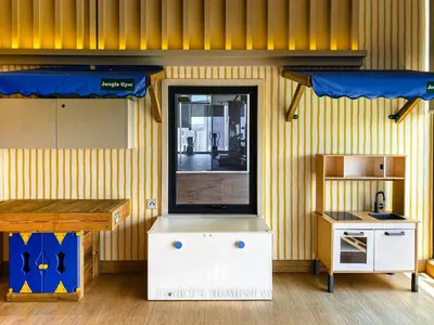 a restaurant with a yellow wall with a counter and a table at Continew Residence by Janice's Homestay in Kuala Lumpur