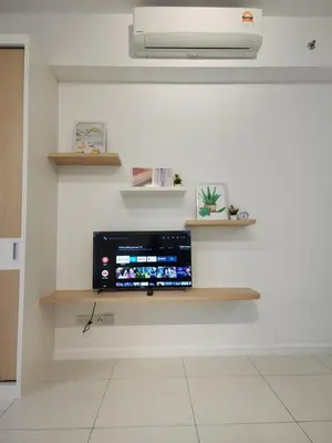 a tv sitting on a wall with shelves at Chambers Residence Suites Couple Studio in Kuala Lumpur