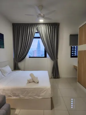 a bedroom with a bed with a ceiling fan and a window at Chambers Residence Suites Couple Studio in Kuala Lumpur