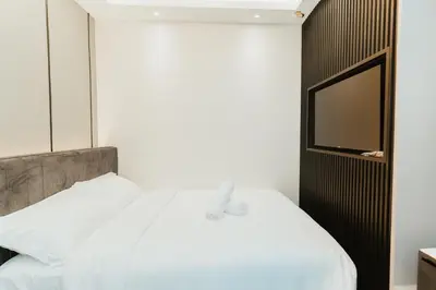 a bedroom with a white bed and a television at Brilliant Hotel Dan Spa in Kuala Lumpur