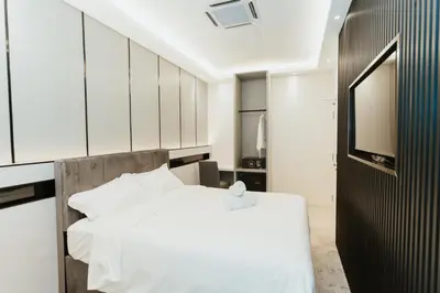 a bedroom with a white bed and a television at Brilliant Hotel Dan Spa in Kuala Lumpur