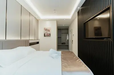 a bedroom with a white bed and a black wall at Brilliant Hotel Dan Spa in Kuala Lumpur