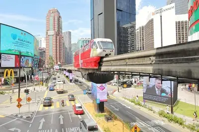 a train on a bridge over a busy city street at Fahrenheit Bukit Bintang Big Group 13Pax Family Suites in Kuala Lumpur