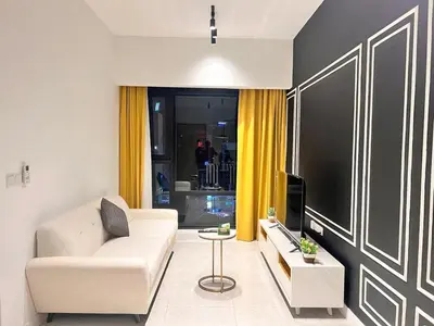 a living room with a white couch and a tv at AXON Residences Kuala Lumpur in Kuala Lumpur