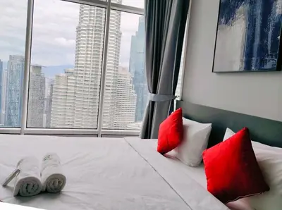 a bedroom with red and white pillows and a window at Sky Suites KLCC by KD Luxury Suites in Kuala Lumpur