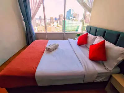 a bedroom with a bed with red pillows and a window at Sky Suites KLCC by KD Luxury Suites in Kuala Lumpur