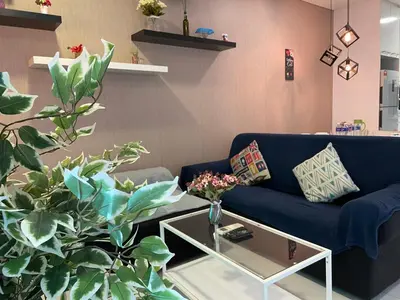 a living room with a blue couch and a table at De Home at Summer Suites KLCC in Kuala Lumpur