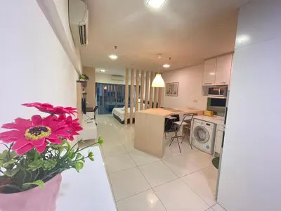 a kitchen and living room with a vase with a flower at De Home at Summer Suites KLCC in Kuala Lumpur