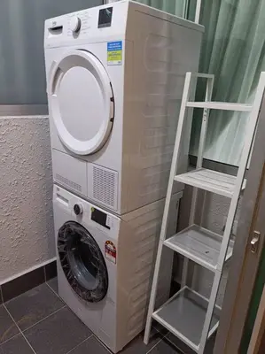 a washing machine with a ladder next to a washer at KLCC View 3BR 3Bath at RC Residence by Rosaz in Kuala Lumpur