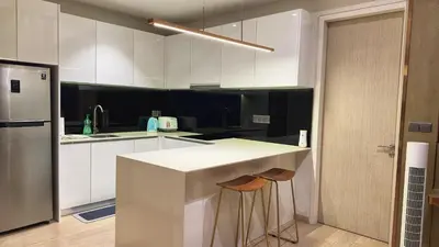 a kitchen with a white counter and a refrigerator at Star Xtian Apartment KLCC in Kuala Lumpur