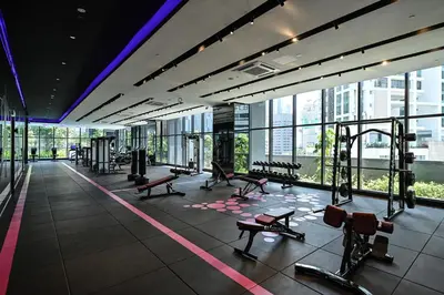 a gym with benches and equipment in a building at Star Xtian Apartment KLCC in Kuala Lumpur