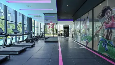 a gym with treadmills and a painting on the wall at Star Xtian Apartment KLCC in Kuala Lumpur
