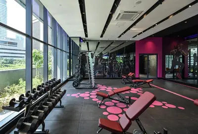 a room with chairs and a gym with purple walls at Star Xtian Apartment KLCC in Kuala Lumpur