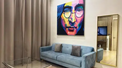 a living room with a blue couch and a painting at Star Xtian Apartment KLCC in Kuala Lumpur