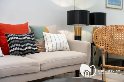 a living room with a couch with colorful pillows at The Signature Serviced Apartment at Sri Hartamas in Kuala Lumpur