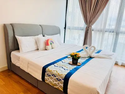 a bed with two towels and a tray of flowers on it at Velocity KL by Homestay in Kuala Lumpur