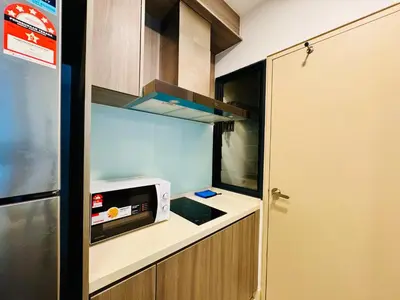 a small kitchen with a microwave and a refrigerator at Velocity KL by Homestay in Kuala Lumpur