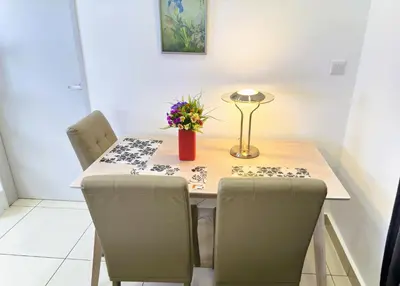 a dining room table with chairs and a vase of flowers at KLCC View 1BR cozy suite with Balcony Trion B5310 KL in Kuala Lumpur