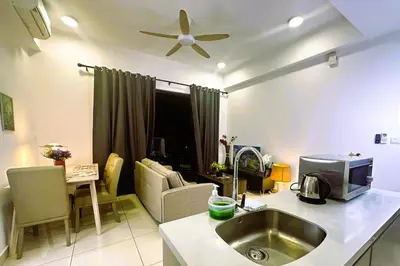 a kitchen with a sink and a living room at KLCC View 1BR cozy suite with Balcony Trion B5310 KL in Kuala Lumpur