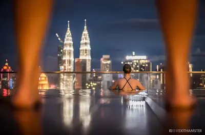 a person in a infinity pool with a view of the city at Regalia Infinity Skypool in Kuala Lumpur