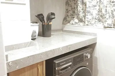 a kitchen with a washing machine under a counter at Residensi Rampai 2 - lake view in setapak in Kuala Lumpur