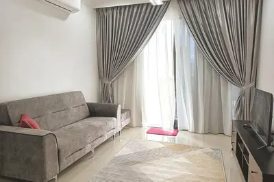 a living room with a couch and a large window at Residensi Rampai 2 - lake view in setapak in Kuala Lumpur