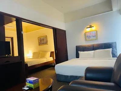 a hotel room with a bed and a chair at Gorgeous service suite at Imbi in Kuala Lumpur