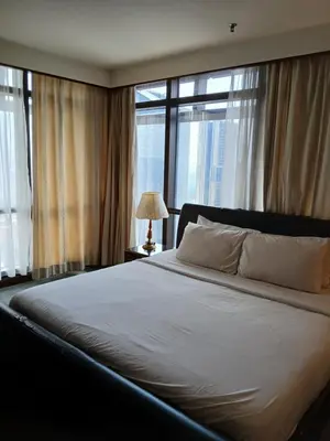 a large bed in a bedroom with windows at Gorgeous service suite at Imbi in Kuala Lumpur