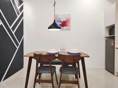 a dining room table with chairs and aendant light at Chambers Residence KLCC in Kuala Lumpur
