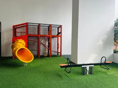 a playground with a slide in a room with green grass at Chambers Residence KLCC in Kuala Lumpur