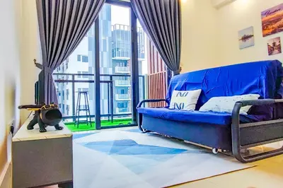 a blue couch in a room with a large window at KL City View at Trion 2 by HCK in Kuala Lumpur