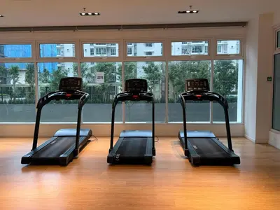 a gym with three treadmills in front of a window at 2BR Centre MontKiara 4px 500Mbps in Kuala Lumpur