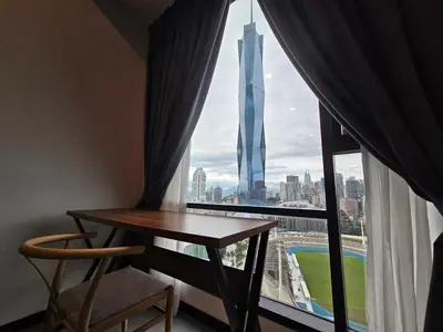 a room with a table and a window with a view of the burj tower at Opus Residences by Star Haven in Kuala Lumpur