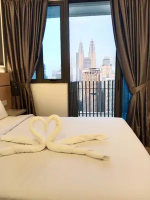 a bed with two swans made to look like hearts at The Luxe KLCC by NZ in Kuala Lumpur