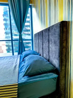 a bed with blue pillows in a room with a window at Nordic Europe Style in Kuala Lumpur