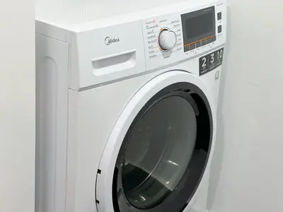 a white washing machine against a white wall at Una Serviced Apartment by Manhattan Group in Kuala Lumpur