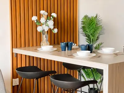 a table with two chairs and a vase of flowers at Una Serviced Apartment by Manhattan Group in Kuala Lumpur