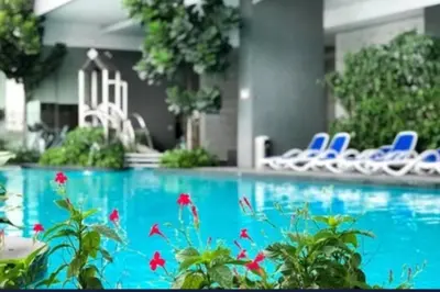 a swimming pool with blue chairs and flowers at 0203s Sweet Home-Casa Residency in Kuala Lumpur