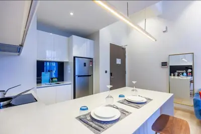a white kitchen with two plates on a counter at Star Luxury By Star Residences KLCC in Kuala Lumpur
