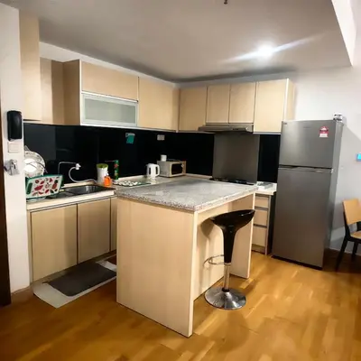 a small kitchen with a counter and a refrigerator at KL Sentral Dua Sentral King Bedroom Suite With Merdeka 118 and KLCC View #FreeParking in Kuala Lumpur