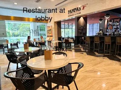 a restaurant with tables and chairs in a mall at 8 KLCC 5 minutes to Jalan Alor Street Bukit Bintang Pavilion 10 Pax 3R2B in Kuala Lumpur
