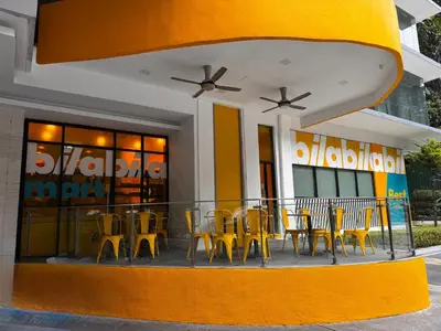 a restaurant with yellow tables and chairs in front of a building at 8 KLCC 5 minutes to Jalan Alor Street Bukit Bintang Pavilion 10 Pax 3R2B in Kuala Lumpur
