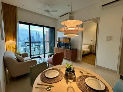 a living room with a dining table with a view of the city at 1BR condo with Amazing KLCC View & Infinity Pool at Lalaport Bukit Bintang in Kuala Lumpur