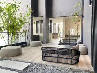 a living room with tables and chairs and plants at 1BR condo with Amazing KLCC View & Infinity Pool at Lalaport Bukit Bintang in Kuala Lumpur